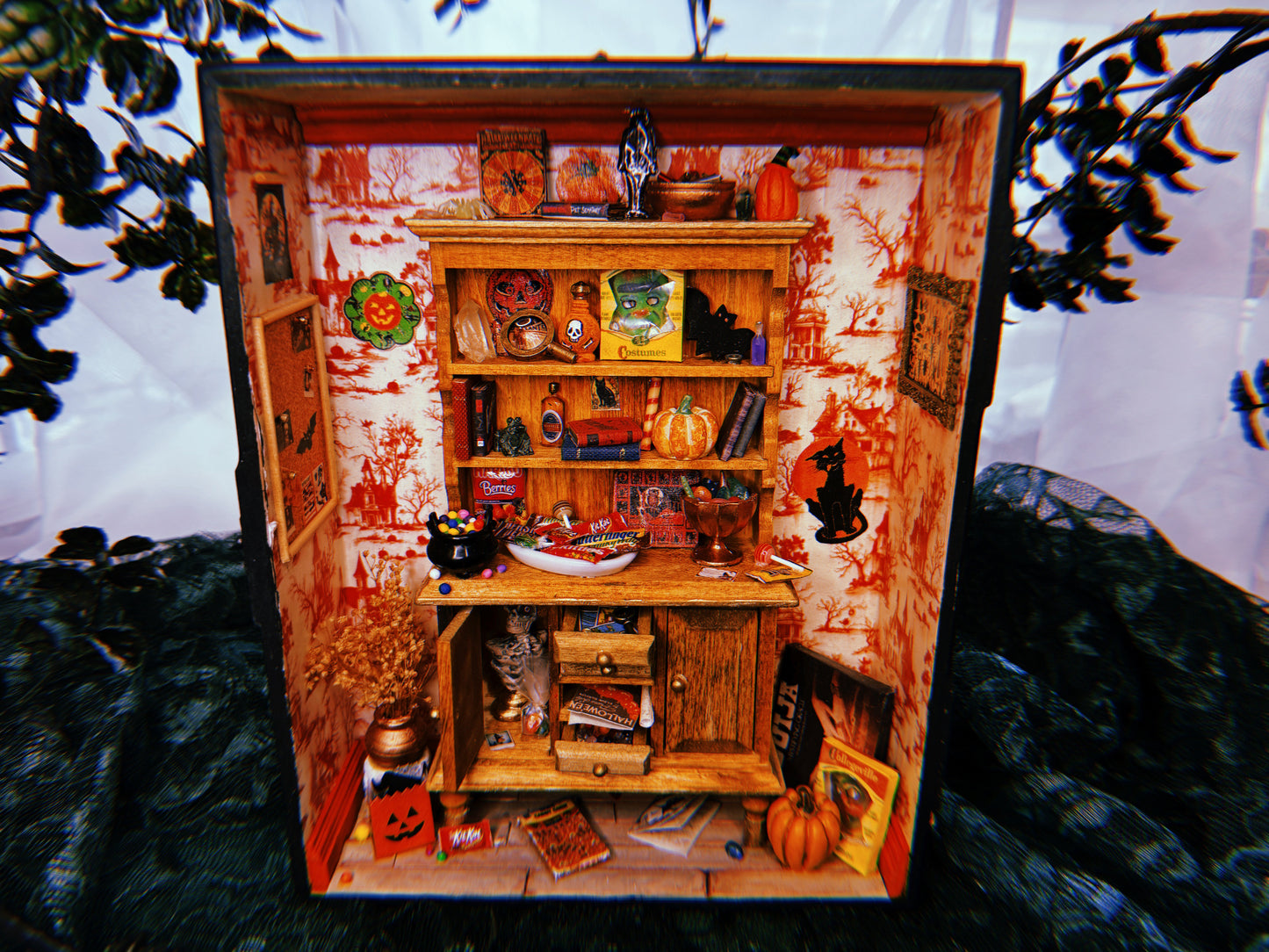 A miniature Halloween-themed diorama featuring a room full of festive candy, games, and spooky wall decorations.