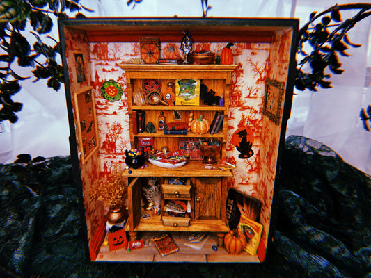 A miniature Halloween-themed diorama featuring a room full of festive candy, games, and spooky wall decorations.