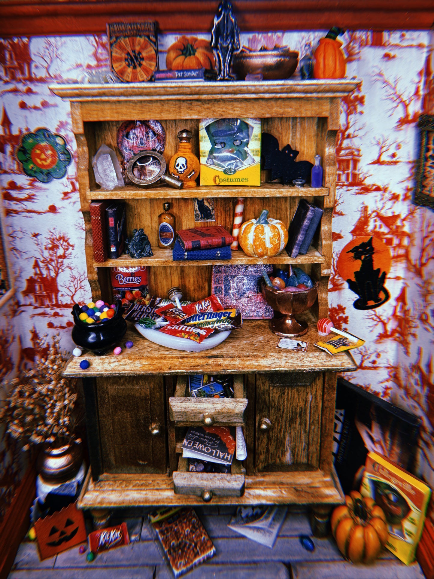 A miniature Halloween-themed diorama featuring a room full of festive candy, games, and spooky wall decorations.