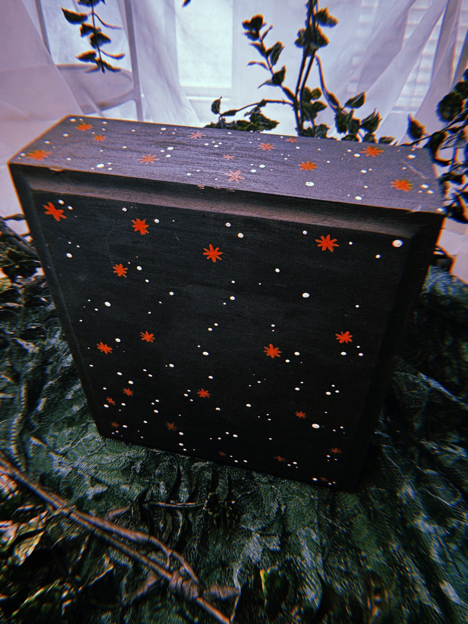 Reverse side of the miniature, painted black with white speckles and burnt orange starburst patterns