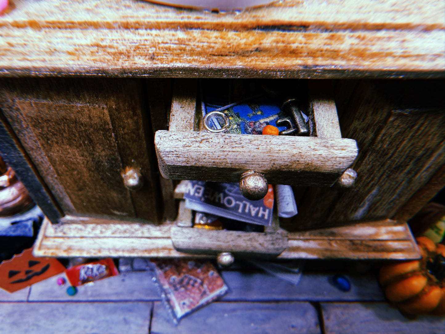Close up of the hutch's drawers, slightly ajar and revealing trinkets like keys and tarot cards.