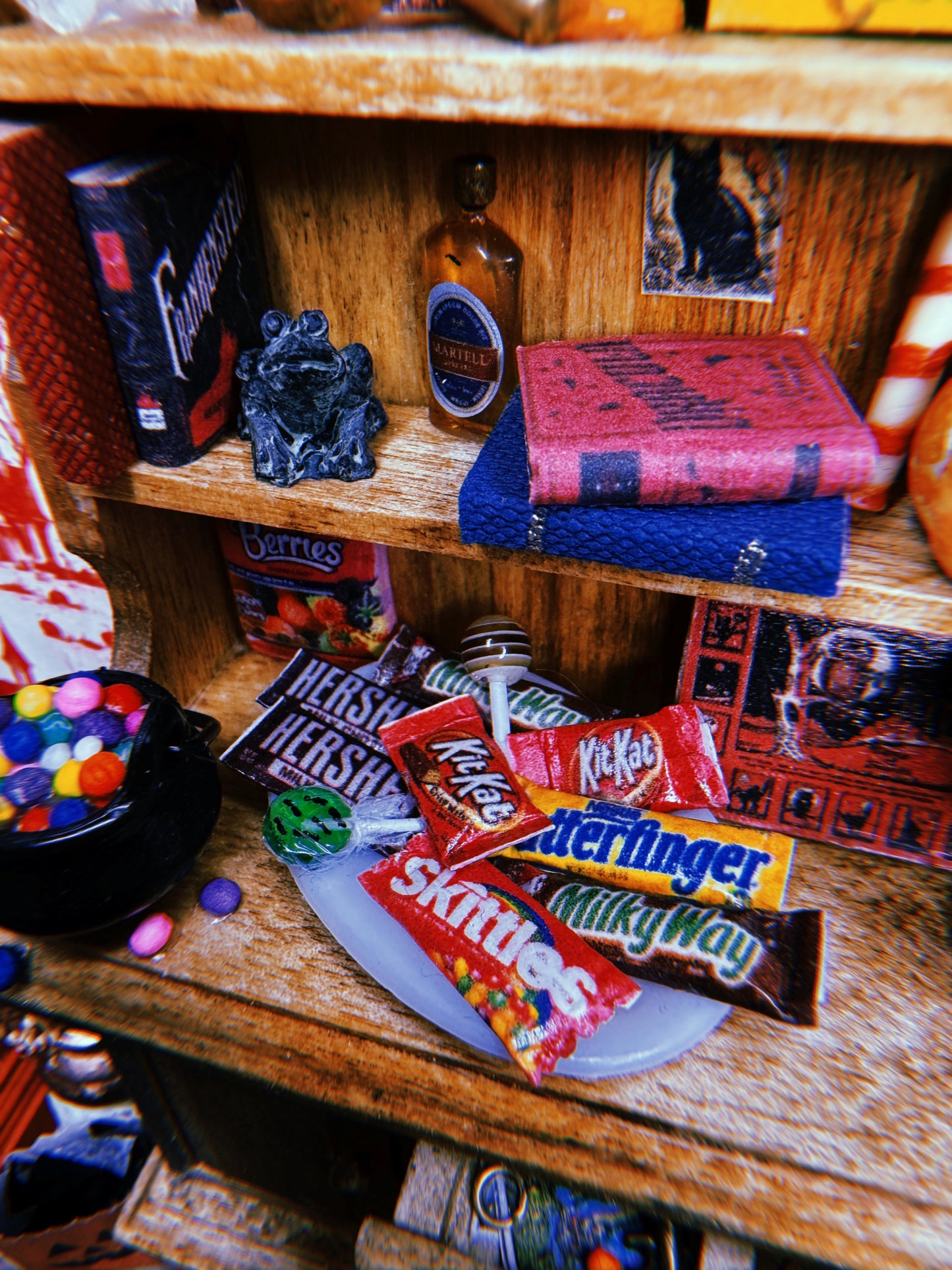 The hutch shelves filled with various items; spooky books, trays of candy bars and lollipops, postcards, and board games.